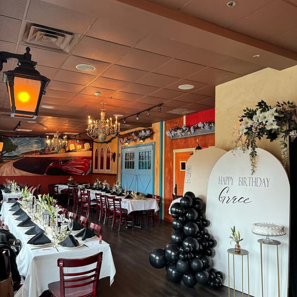 Lola Latin Bistro's dining room set for a "Happy Birthday Grace" celebration with long tables and decor.